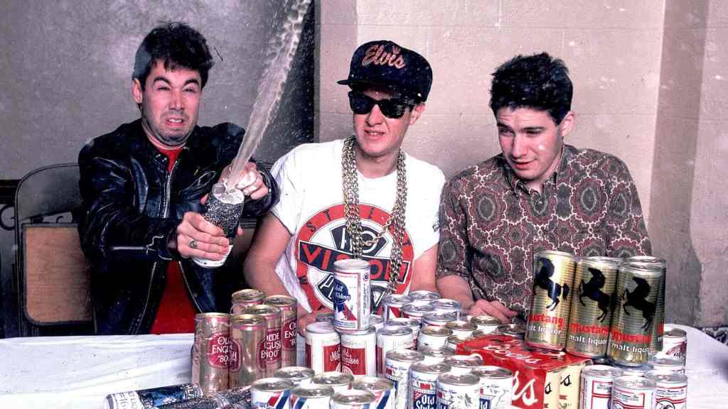 Le groupe de rap Beastie Boys sur une table remplis de cannettes de bières